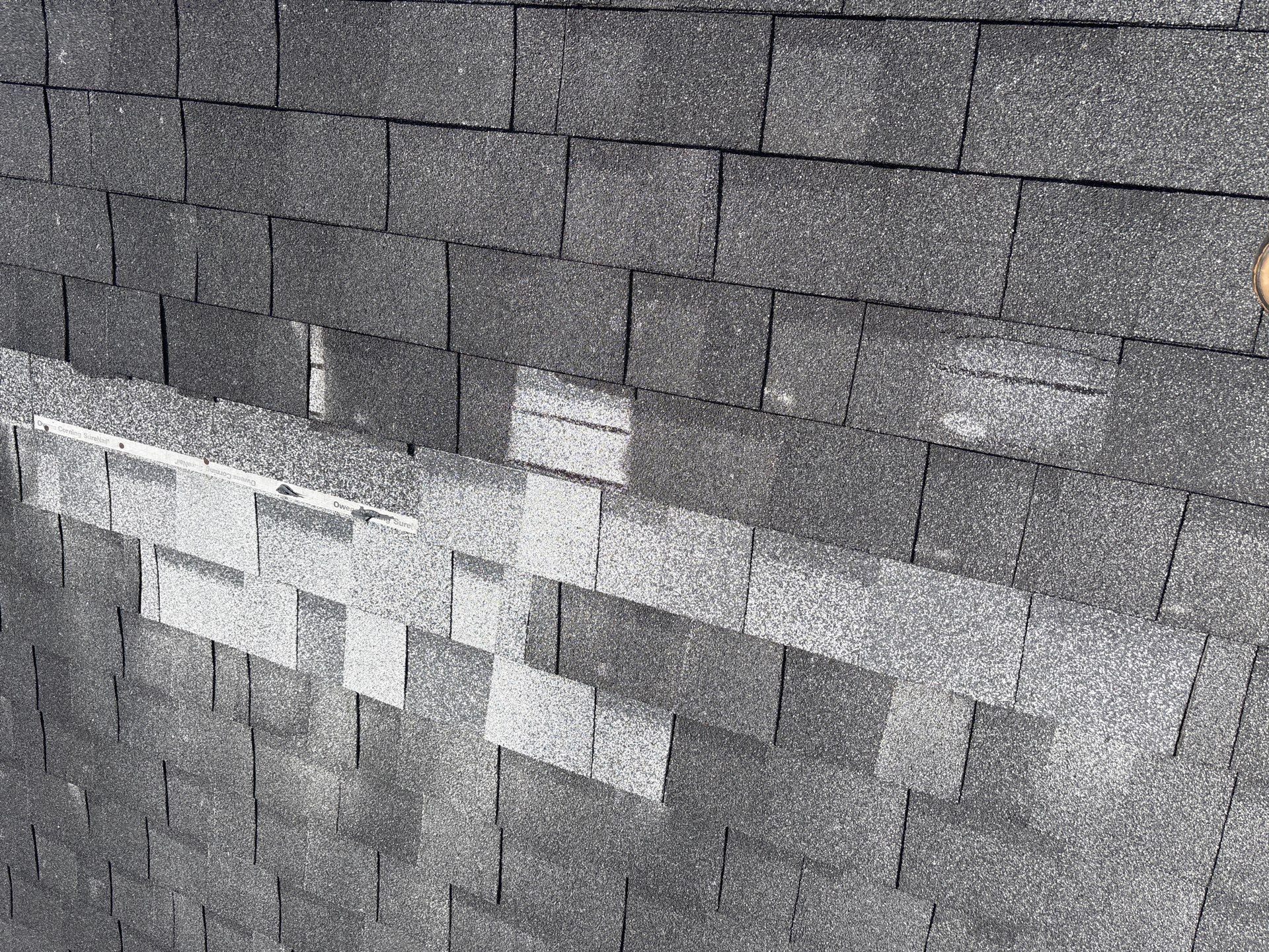 Aerial view of storm-damaged shingle roof in Texas
